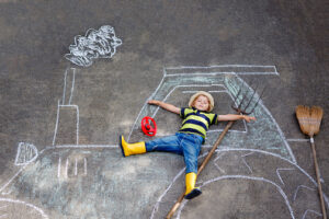 little boy lying on a chalk train he drew