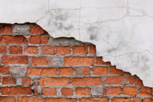 brick wall partly covered by plaster