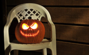 Halloween pumpkin on chair on porch