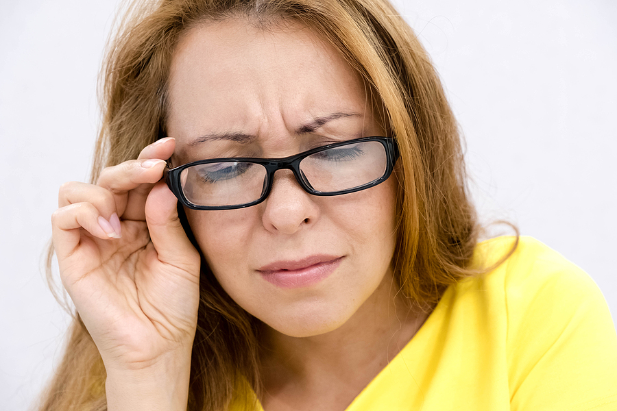 40-ish woman with glasses having trouble reading