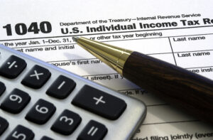 American 1040 income tax form with calculator and pen