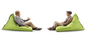 two old men sitting on bean bag chairs